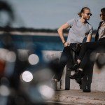 Selective focus of young couple on quay with motorbike on foreground