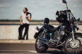 selective focus of chopper motorcycle and biker on background