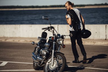 nehir ile şehirde chopper motosiklet ile genç motorcu