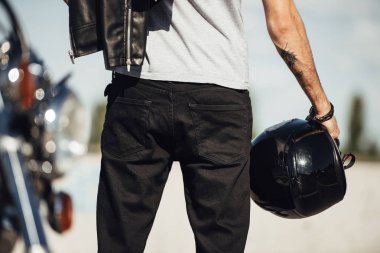 Erkek motorcu motosiklet kask tutan midsection görünümü