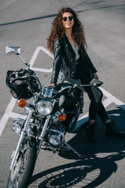 Klasik Motosiklet kentsel park üzerinde oturan mutlu kadın motorcu 