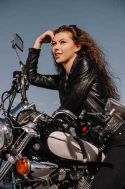 Vintage klasik motosiklet üzerinde oturan çekici kadın motorcu