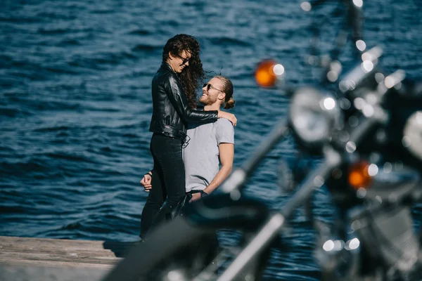 Gelukkige Paar Fietsers Knuffelen Kade Met Motorfiets Voorgrond — Stockfoto