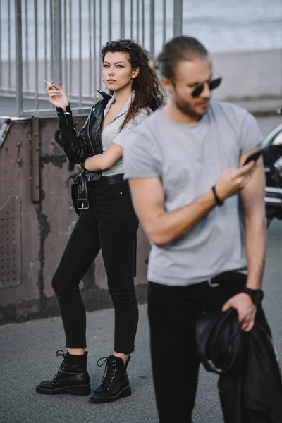 Φίλο Χρησιμοποιώντας Smartphone Ενώ Στέκεται Κλασικής Μοτοσικλέτας Φόντο Φίλη — Δωρεάν Φωτογραφία