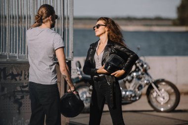 Klasik Motosiklet duran kask motorcularla genç çift 