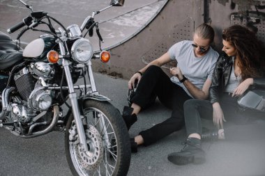 kız ve erkek arkadaşı ile klasik chopper motosiklet asfalt üzerinde oturan