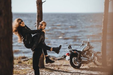 eğleniyor ve onun kız arkadaşı sahil motosiklet ile silah tutan erkek