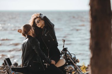 deniz kıyısı motosiklet bisikletçileri üzerinde kucaklayan birkaç helikopter