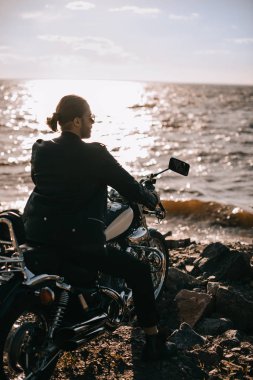 Klasik Motosiklet arka ışık ile deniz kenarında oturup..... yakışıklı motorcu