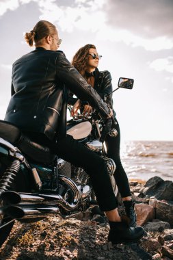 Çift siyah deri ceket ile deniz kenarında chopper motosiklet bisikletçileri