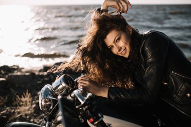 motosiklet üzerinde oturan gülümseyen güzel kadın