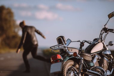 arka planda, seçici odak kızgın motorcu ile yolda kırık klasik motosiklet