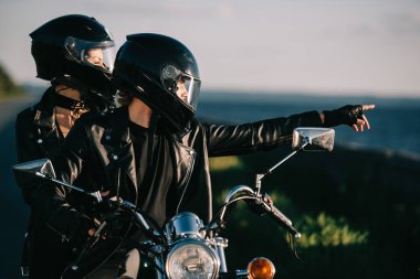 kask üstünde motosiklet, adam bir şey kız arkadaşına gösterilen motorcu