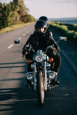 Genç iki ülke yolda klasik motosiklet sürme kask içinde