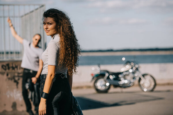 selective focus of girlfriend and boyfriend with classical motorbike 
