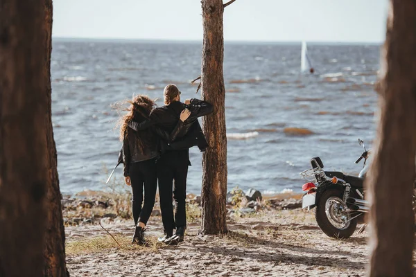 ハグして海では バイクの近くに立っているバイカーのカップルの背面図 — ストック写真