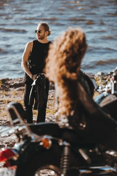 女の子のバイクに座っていると 海岸の上を歩く彼氏を見ての選択と集中 — ストック写真