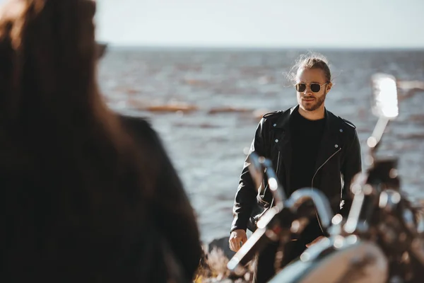 Selektywny Fokus Kobiet Rowerzysta Siedzi Motocyklu Patrząc Mężczyznę Idącego Seashore — Darmowe zdjęcie stockowe