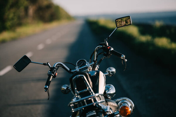 мотоцикл крейсера, стоящий на пустой дороге
