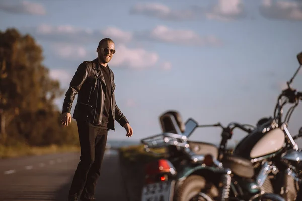 Przystojny Mężczyzna Stojący Drodze Klasyczny Motocykl Selektywny Fokus — Darmowe zdjęcie stockowe