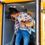 Afryki amerykański student zaraz po wyjściu z autobusu szkolnego