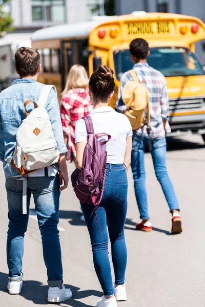 Widok Tyłu Grupy Nastolatków Dorywczo Studentów Plecakami Chodzenia Szkoły Autobusem — Zdjęcie stockowe