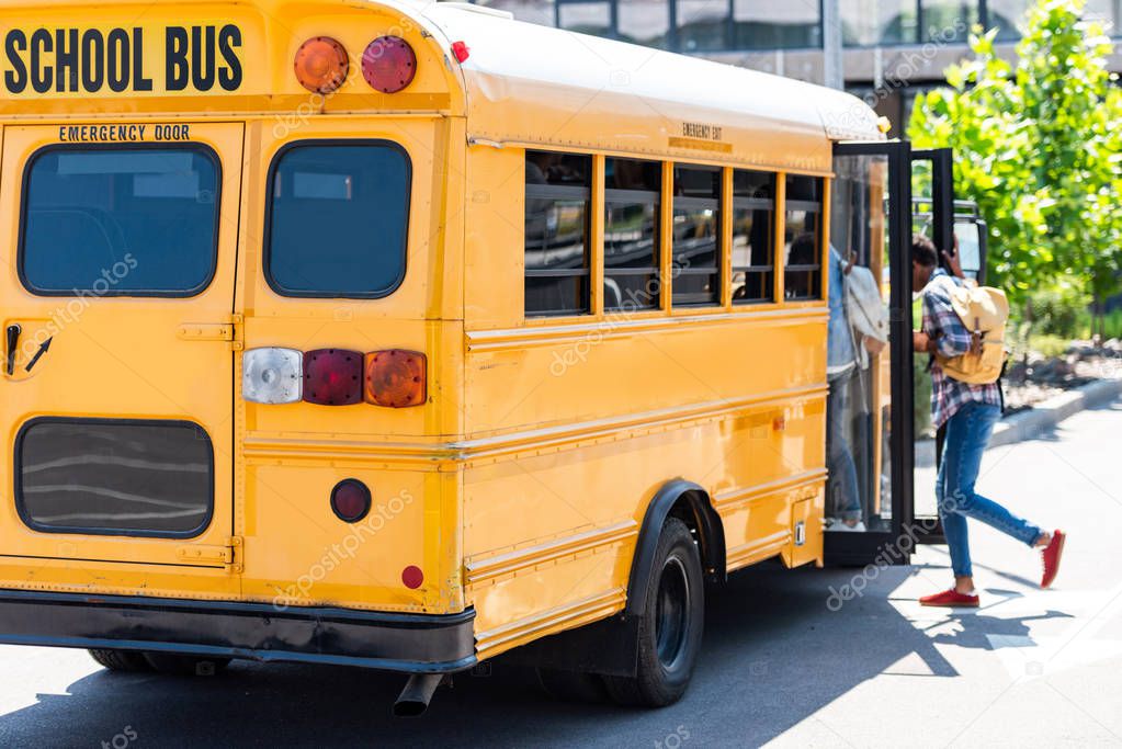 students walking into school bus at parking