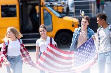 ABD bayrağı önünde okul otobüsü ile yürüme Amerikan genç bilim adamlarının Grup