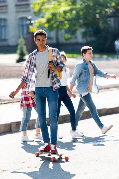 Stilig Unga Afrikanska Amerikanska Skolpojke Ridning Skateboard Med Suddiga Klasskamrater — Stockfoto