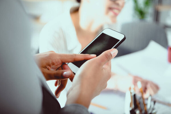 Обрезанный снимок бизнесвумен с помощью смартфона с чистым экраном
