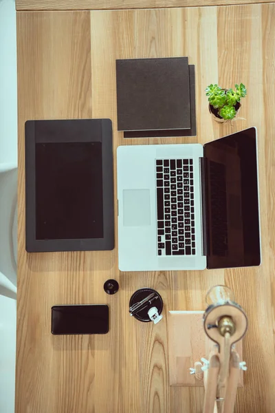 グラフィック タブレットやスマート フォンとノート パソコンのオフィスで木製のテーブルの上の平面図 — ストック写真