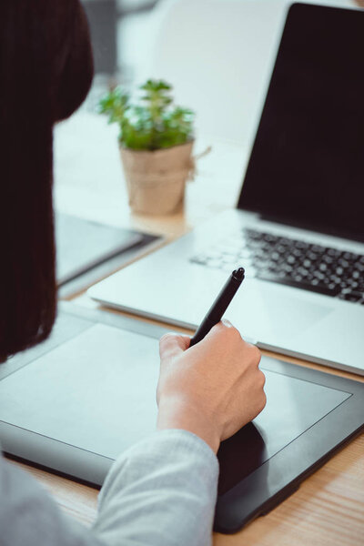 обрезанный снимок дизайнерского рисунка на графическом планшете на рабочем месте
