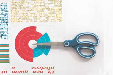 Top view of scissors and colorful business chart at workplace clipart
