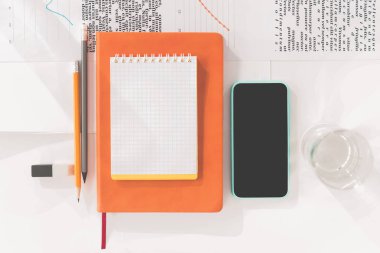 Boş ekran, defter ve kalemler işyerinde smartphone'un Üstten Görünüm