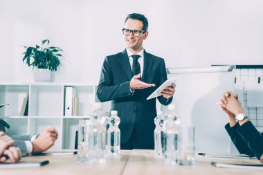 Konferans Salonu, ortaklara konuşurken tablet ile mutlu işadamı