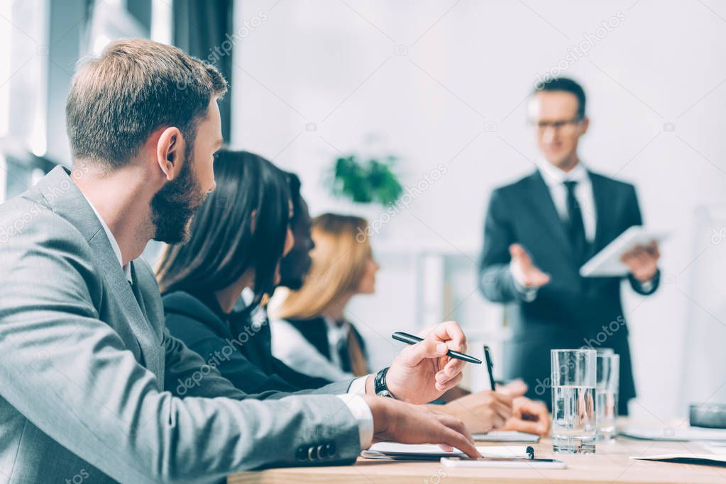 successful multiracial businesspeople having conversation in conference hall