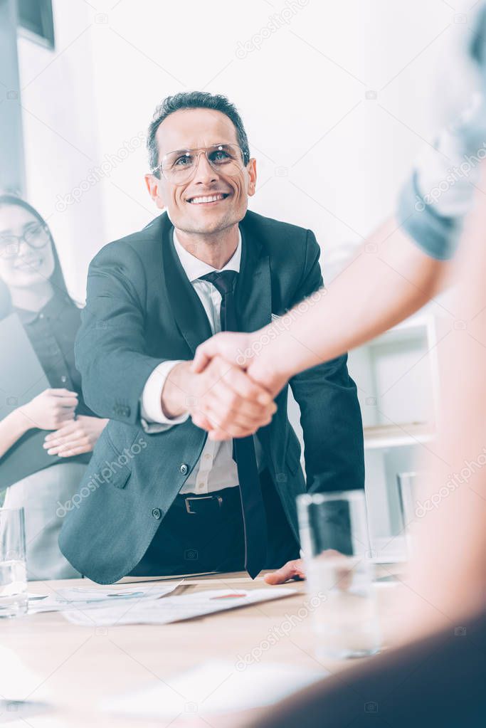 business partners shaking hands in modern office
