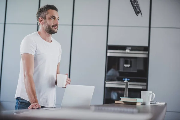 Handsome Man Holding Cup Coffee Looking Away Kitchen — Stock Photo, Image