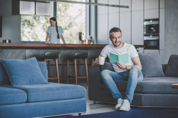 Sorrindo Homem Adulto Com Livro Leitura Café Sofá Enquanto Sua — Fotografia de Stock
