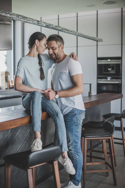 Mujer Sonriente Sentada Mostrador Cocina Abrazando Novio Casa —  Fotos de Stock