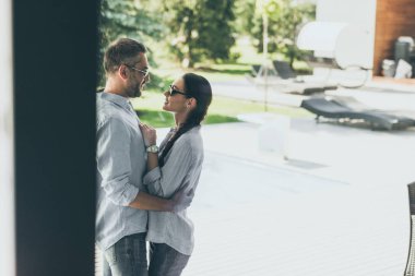 Güneş gözlüklü kız kır evinde sarılma gülümseyen adam 