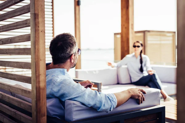 Homem Adulto Óculos Sol Sentado Sofá Falando Com Namorada Casa — Fotografia de Stock