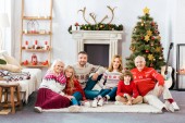 happy family sitting on floor together at home on christmas