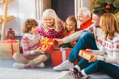 güzel mutlu aile ile Noel sırasında oturma odası katta oturan hediye kutuları