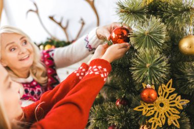 mutlu büyükanne ve torunu birlikte Noel ağacı süsleme