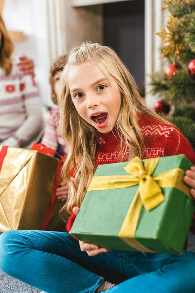 Chockad Litet Barn Med Julklapp Tittar Kameran — Stockfoto