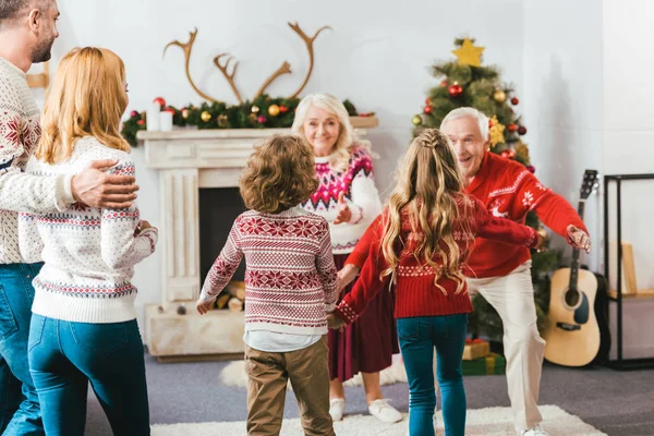 Achteraanzicht Van Kinderen Lopen Omhelzen Grootouders Tijdens Kerstavond Thuis — Stockfoto