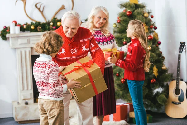 Abuelos Sonrientes Dando Cajas Regalo Para Niños Navidad — Foto de Stock