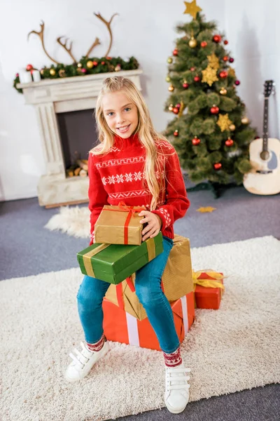 Adorable Happy Child Sitting Stacked Christmas Gift Boxes — Free Stock Photo