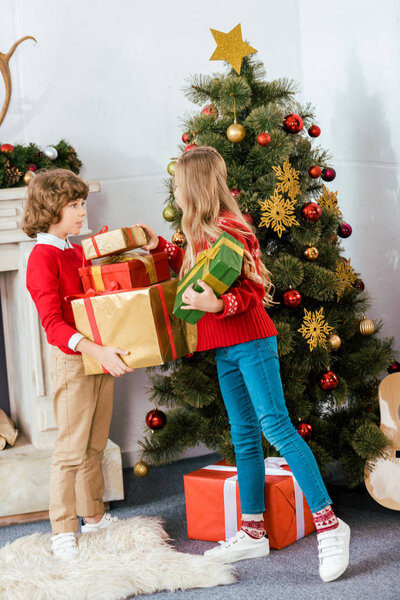 adorable little siblings with gift boxes celebrating christmas